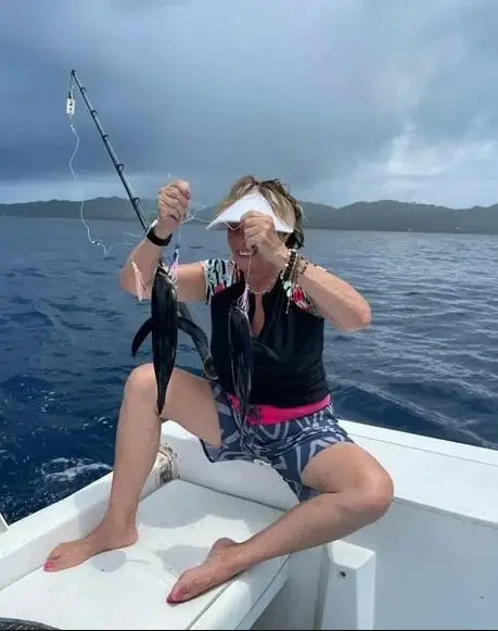 Lady holding triple blackfin tuna catch on a Roatan deep sea fishing charter with Dos Reyes Roatan