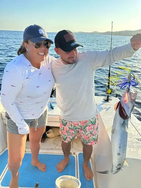 Couple admiring large Barracuda, deep sea fishing Roatan, private boat charter, Caribbean adventure, Dos Reyes Roatan