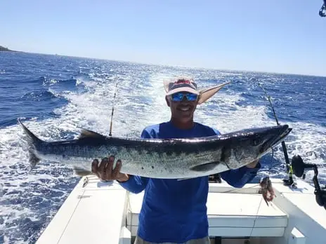 First Mate Eddie holding a big Barracuda, deep sea fishing Roatan, private boat charter, Caribbean adventure, Dos Reyes Roatan