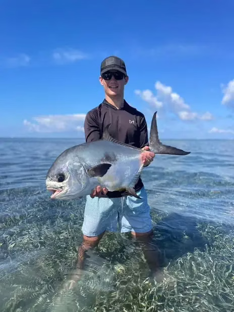 Teenager smiling with Permit fish, flat fishing Roatan, family-friendly private charter, Caribbean adventure, Dos Reyes Roatan