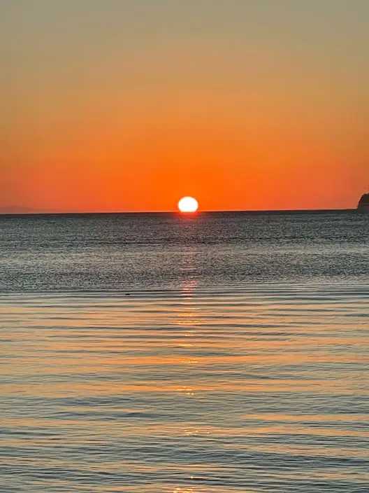 Incredible sunset in Roatan viewed from a Dos Reyes private charter — Caribbean boat tour with golden skies, turquoise waters, and unforgettable island beauty