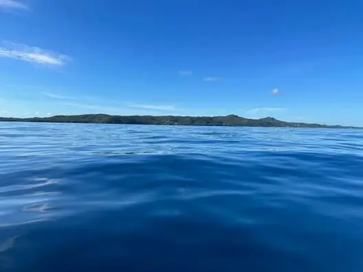 Approaching Jade Beach from a few miles out, Roatan private boat charter, Caribbean snorkeling and island adventure, Dos Reyes Roatan