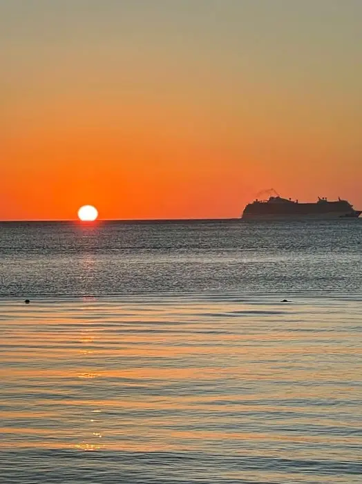 Romantic sunset over the calm Caribbean Sea with Dos Reyes Roatan — private charter cruise for couples, fishing, snorkeling, and island tours in Honduras