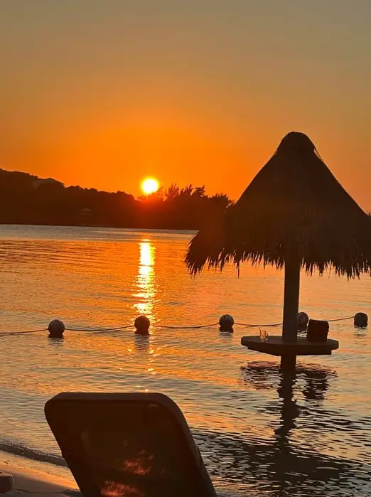 Romantic golden sunset with Dos Reyes private charter at Turquoise Bay, Roatan — exclusive Caribbean cruise for couples, snorkeling, and island tours