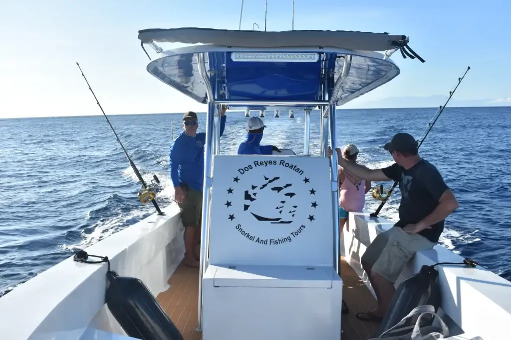 Guests socializing aboard Dos Reyes Roatan Charter while trolling — private deep sea fishing tour in Caribbean waters with friends and family
