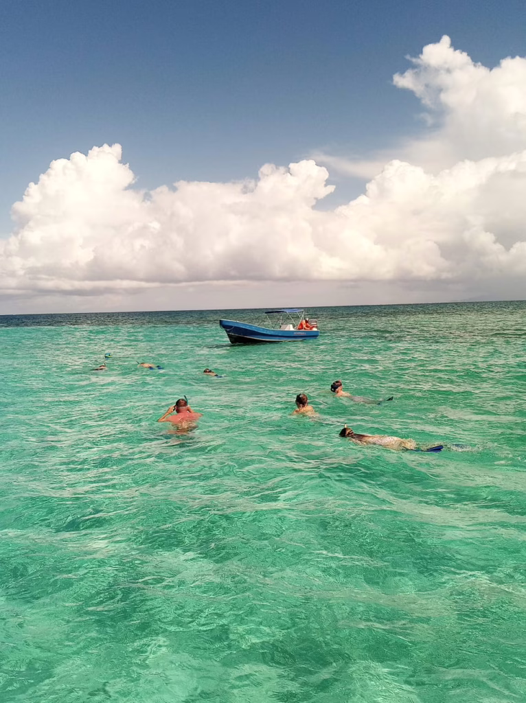 Guests enjoying clear, crystal‑blue snorkeling in Roatán near the Dos Reyes charter
